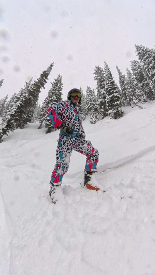 Person wearing the white, teal, pink, and black Miami Ice Shred Suit on snow